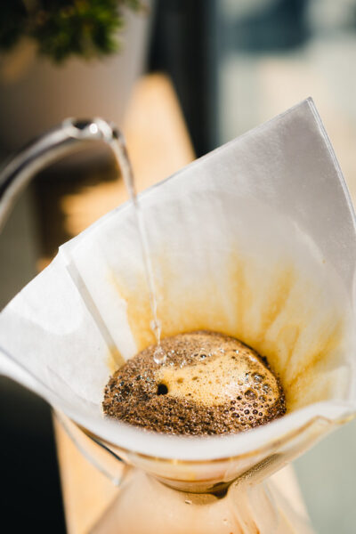 Pouring water onto a bed of coffee using a Chemex