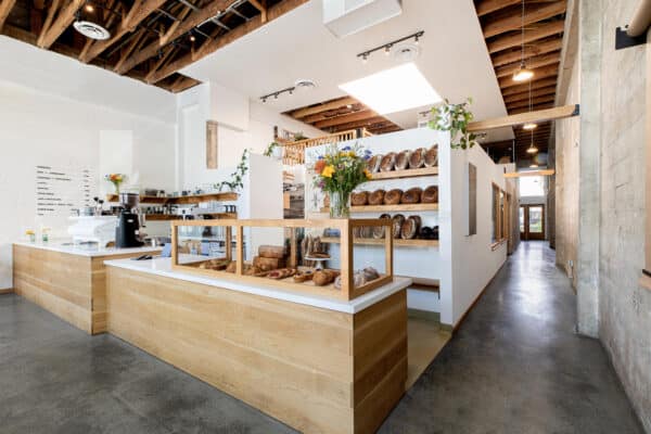 Interior of Backhaus of the front counter with loaves of bread on shelves.