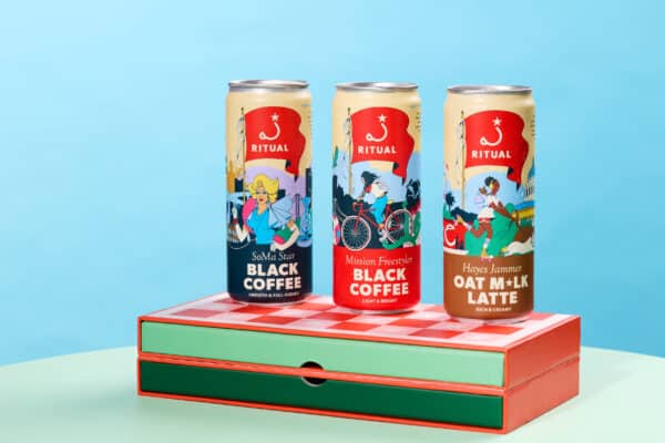 Three canned coffees on top of a dominoes game case