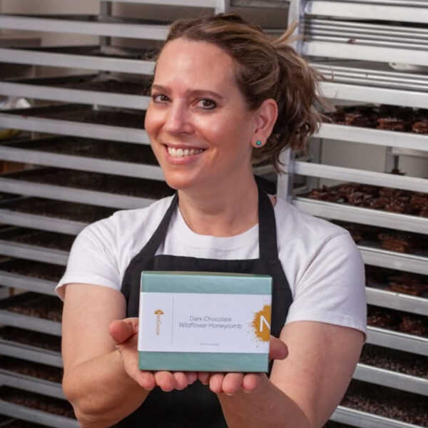 Christine Doerr holding a box of Neococoa Dark Chocolate Wildflower Honeycomb