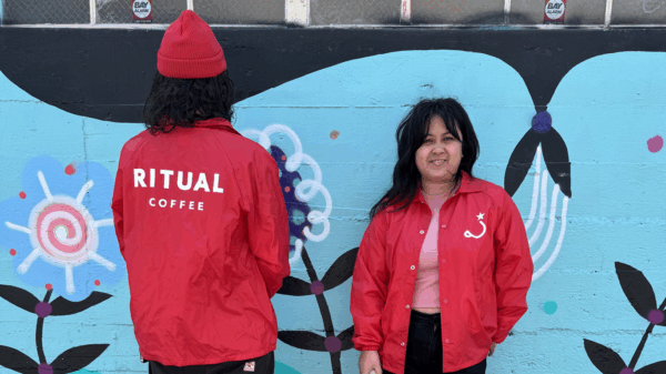 Models wearing coach jackets in front of mural