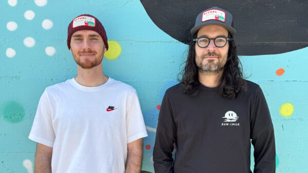 Models wearing a beanie and trucker hat merchandise
