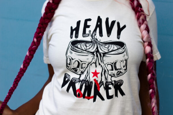 Person wearing an ivory shirt that says "Heavy Drinker"
