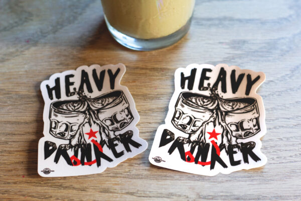 stickers that says "heavy drinker" on a wooden table